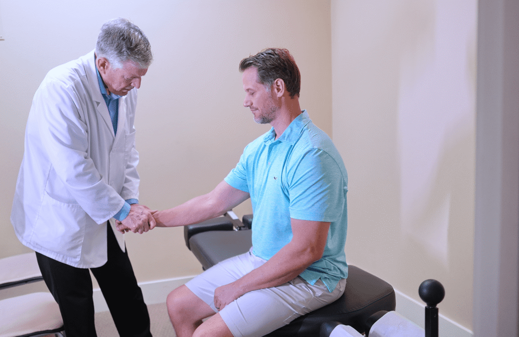 Dr. Timothy Douglass giving the man a arm pain therapy
